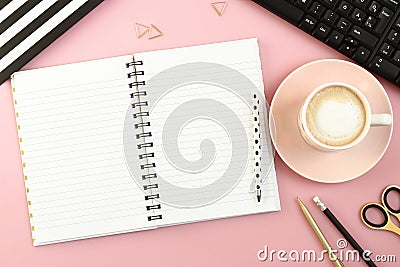 Pink office desk table with open notebook, cup of coffee, pen, pencil, scissors and computer. Stock Photo