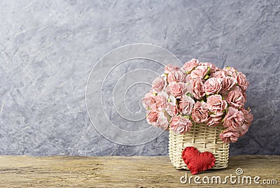 Pink paper carnation in weave basket on old wood Stock Photo