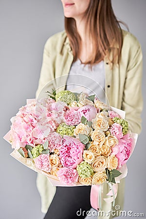 Pink peonies and hydrangea. Beautiful bouquet of mixed flowers in woman hand. Floral shop concept . Handsome fresh Stock Photo