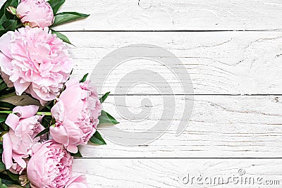 Pink peony flowers over white wooden table with copy space. wedding invitation. flat lay Stock Photo