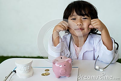 Pink piggy bank with Kid doctor and Medical equipment, Saving money for future plan and Health insurance concept Stock Photo