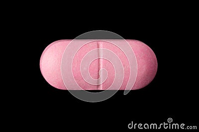 Pink pill isolated on black Stock Photo