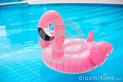 Pink pool float flamingo by blue water, pool party toy. Giant Inflatable Swimming Ring. Summer vacation holiday luxurious resort Stock Photo