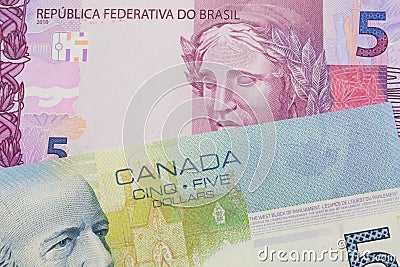 A pink and purple five real bank note from Brazil paired with a blue five dollar bill from Canada. Stock Photo