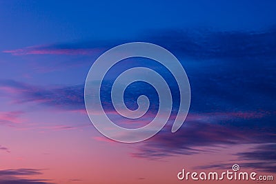 Pink and purple sunset sky with clouds painted in dark tones of blue Stock Photo