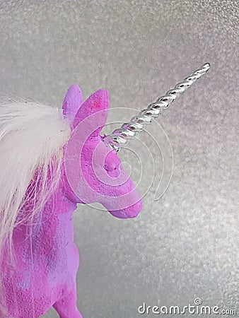 Pink and purple unicorn toy figure on a silver background Stock Photo