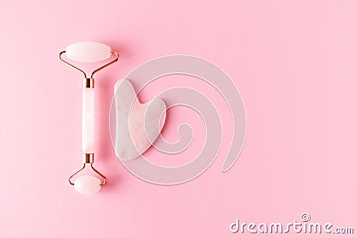 Pink quartz facial roller and gua sha, top view. Trendy skincare facial massager Stock Photo