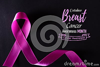 Pink ribbon on black paper background for supporting breast cancer awareness month campaign Stock Photo