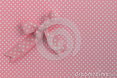 Pink ribbon on polka dots. Stock Photo