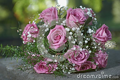 Pink rose wedding bouquet with two gold ring Stock Photo