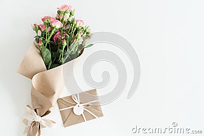 Pink roses bouquet in kraft paper and envelope isolated on white with copy space Stock Photo