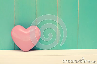 Pink shiny heart on vintage teal wood Stock Photo