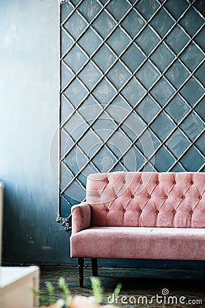 Pink sofa on blue wall background, place for inscription Stock Photo