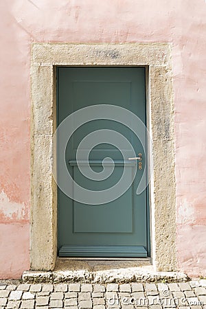 Pink stone wall with green door Stock Photo