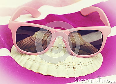 Pink sunglasses on beach towel Stock Photo