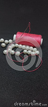 pink thread, needle and beads Stock Photo