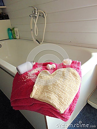 Pink towel on bathtub with bath glove Stock Photo