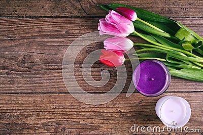 Pink Tulip Flowers and two cendels on rustic table for March 8, International Womens Day, Birthday, Valentines Day or Stock Photo