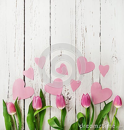 Pink tulips bouquet with paper hearts on wooden background Stock Photo