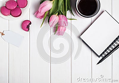 Pink tulips, macarons, empty notepad and coffee on white wooden Stock Photo