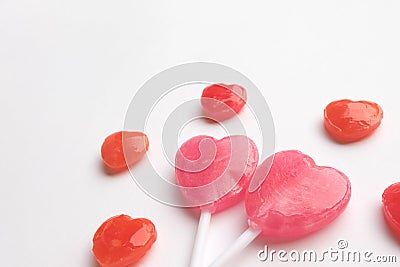 Pink Valentine`s day heart shape lollipop with small red candy in cute pattern on empty white paper background. Love Concept. Min Stock Photo