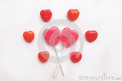 Pink Valentine`s day heart shape lollipop small red candy in cute pattern on empty white paper background. love concept. top view. Stock Photo