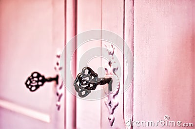 Pink vintage antique doors with old skeleton keys in lock wooden background texture, retro design Stock Photo