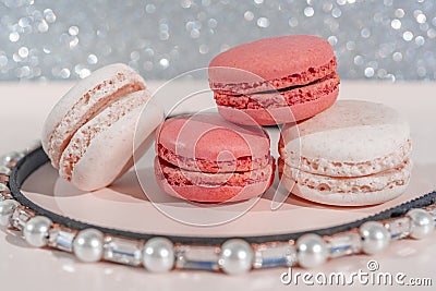 Pink and white macarons on light wooden background with beautiful pearls decoration. French Pastel Macaroons. Blurred focus Stock Photo