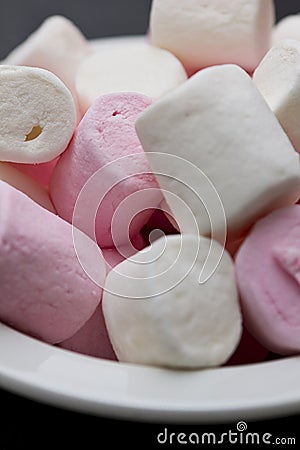 Pink and white marshmallows in white bowl Stock Photo