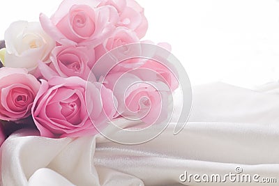 Pink and white roses laying in silk with backlight Stock Photo