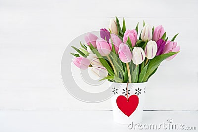 Pink and white tulips bouquet in white vase decorated with red heart. Valentines Day concept. Stock Photo