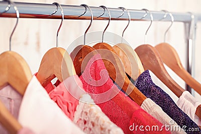 Pink womens clothes on hangers on rack in fashion store. closet Stock Photo