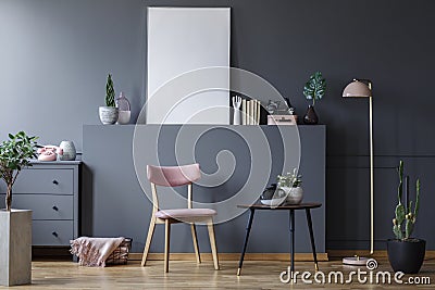 Pink wooden chair at black table in grey living room interior with mockup of empty poster Stock Photo