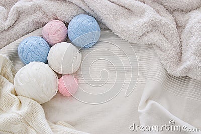 pink& x27; blue and white warm and cozy yarn balls of wool over soft bed. Stock Photo