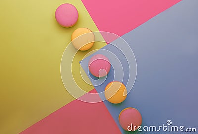 Pink yellow macaroons on yellow blue pink graphic background, neon color, place for text, creative layout, top view Stock Photo