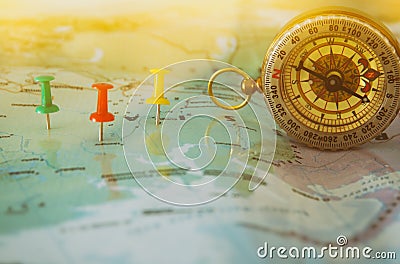 pins attached to map, showing location or travel destination and old compass. Stock Photo