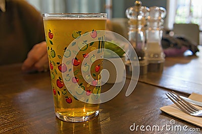 A pint of cider in a restaurant with soft focused background Stock Photo