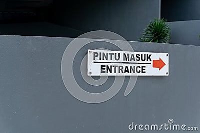 Pintu masuk mean Entrance. Entrance sign on the wall wrote in Bahasa pintu masuk Stock Photo