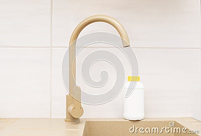 Pipe Drain Granules in White Plastic Bottle With Yellow Cap On Kitchen Sink In Cook Room Stock Photo