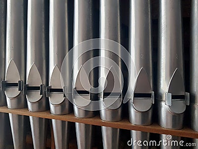 Pipe organ frontal shot, row of silver shiny pipes in sight, abstract, high contrast background Stock Photo