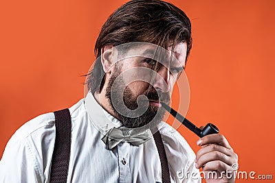 pipe smoking vintage characteristic mature man with moustache and beard, brutality Stock Photo