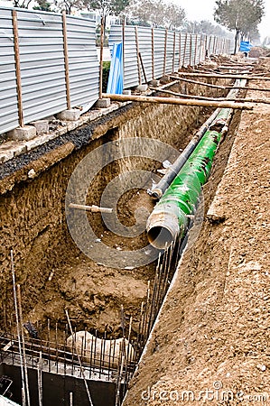 Pipes with heat isolation lieing in the trench. Stock Photo