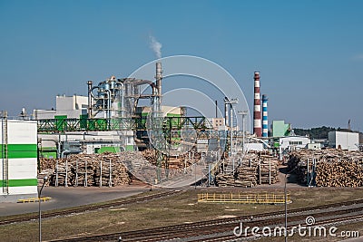 Pipes of woodworking enterprise plant sawmill near river. Air pollution concept. Industrial landscape environmental pollution Editorial Stock Photo