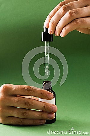 Pipette with Cannabidiol CBD oil in hand. CBD oil from the Cannabis plant to help reduce pain, anxiety, and sleep Stock Photo