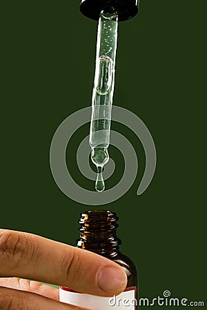 Pipette with Cannabidiol CBD oil in hand close-up. CBD oil from the Cannabis plant to help reduce pain, anxiety, and Stock Photo