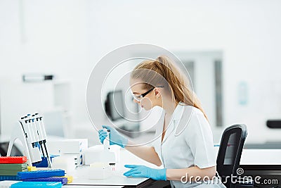 Pipette dropping a sample in a test tube. Laboratory assistant analyzing blood in lab. Aids, hiv test Stock Photo