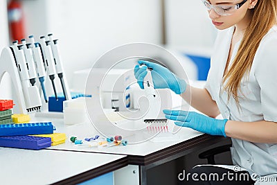 Pipette dropping a sample in a test tube. Laboratory assistant analyzing blood in lab. Aids, hiv test Stock Photo