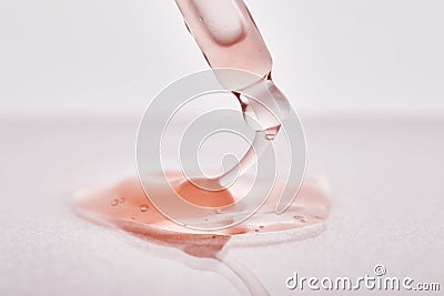 Pipette with a viscous pink cosmetic close-up. Stock Photo