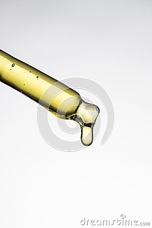 Pipette on white background with dripping liquid. Skincare concept Stock Photo