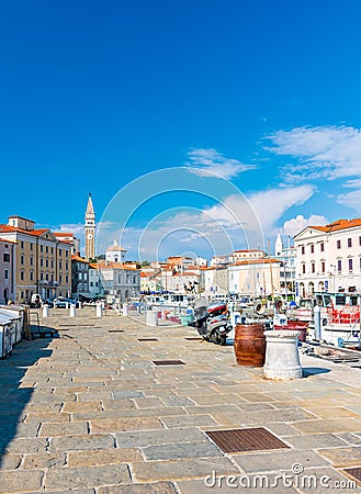 Piran Slovenia: View from Piran harbor to church tower in medieval city. Historic houses and ancient architecture in Slovenia Editorial Stock Photo